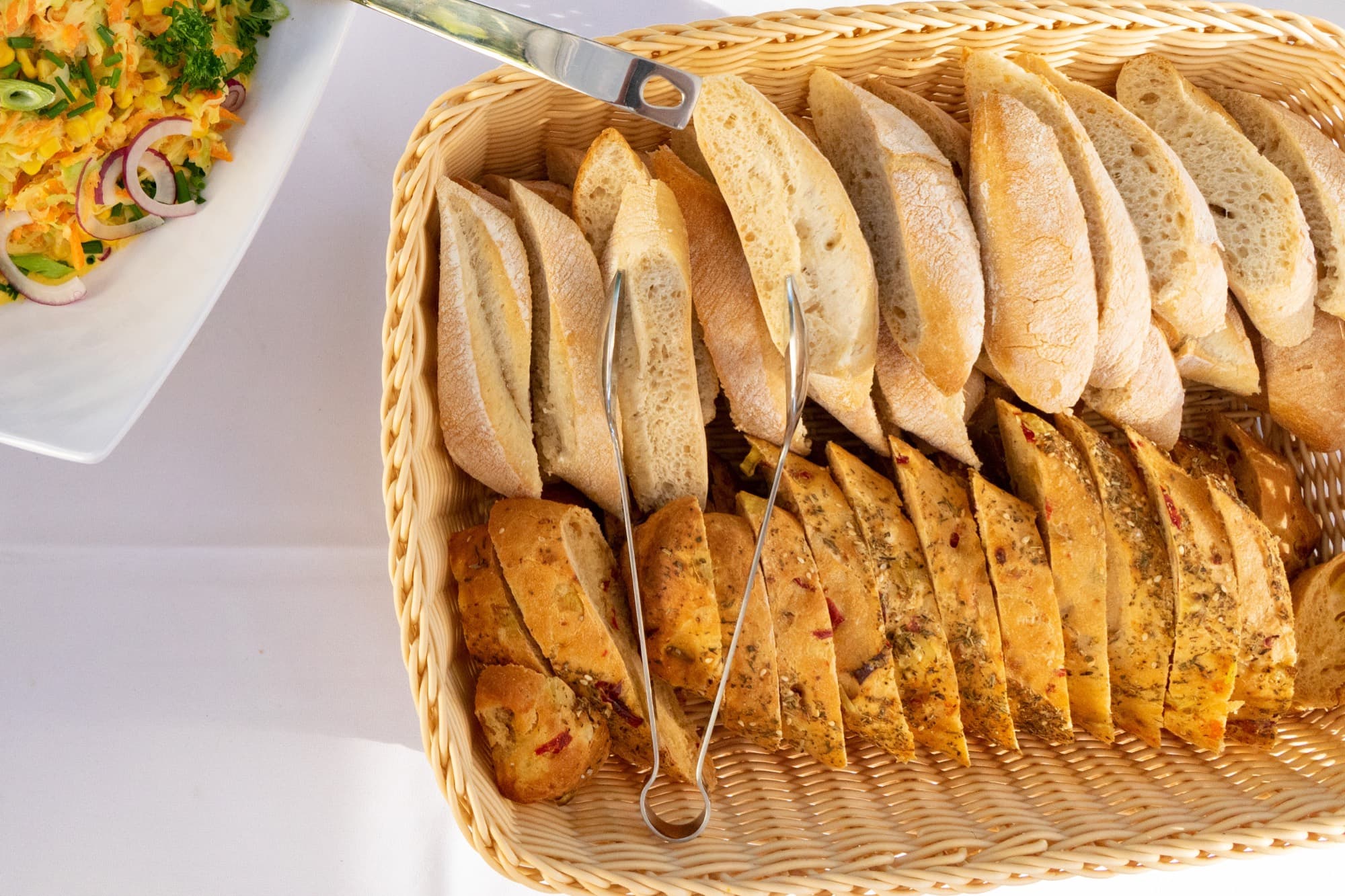 Brotkorb mit Baguette und Kräuterbrot am Buffet