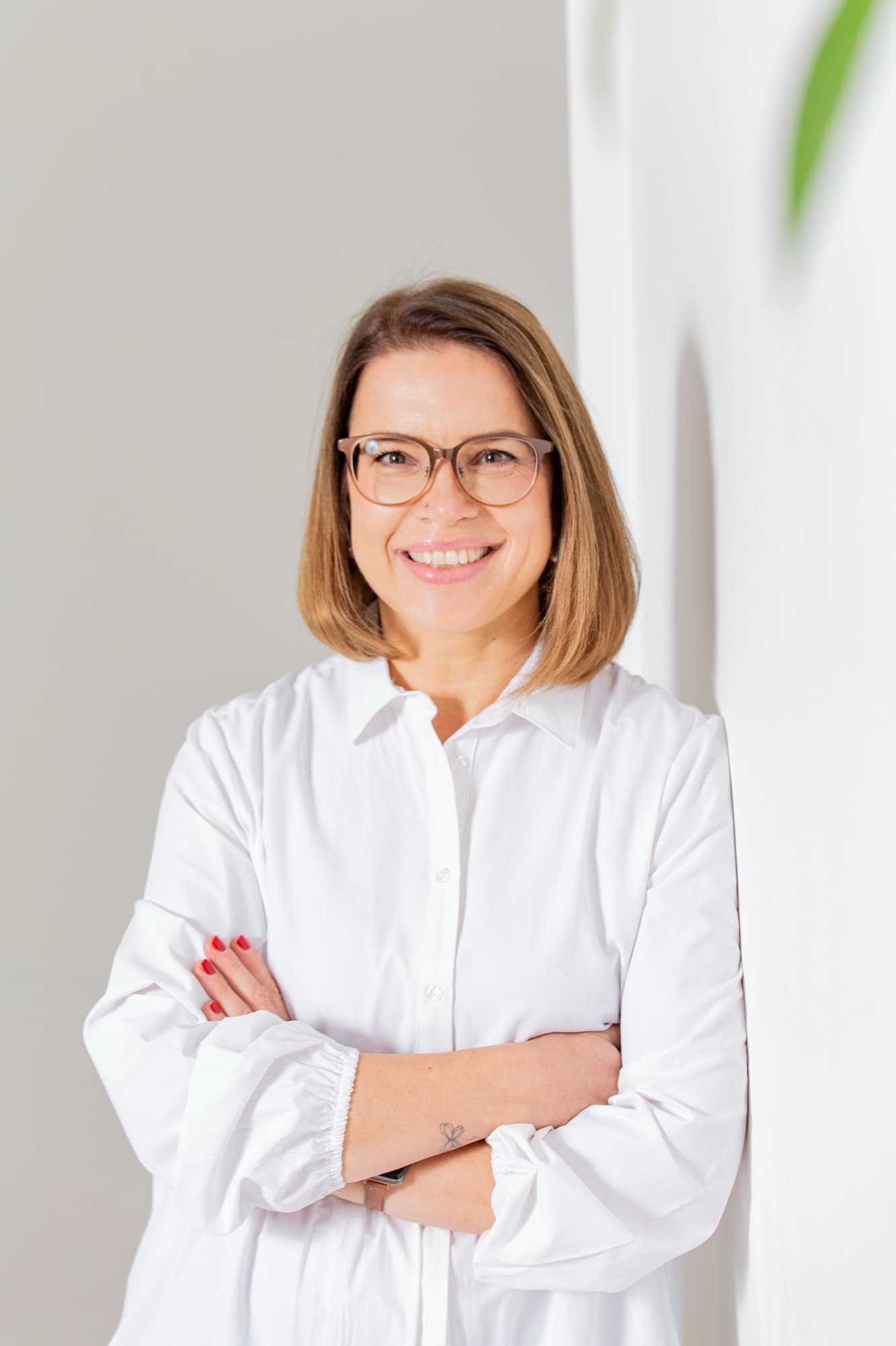 Businessportrait in weißer Bluse vor heller Wand