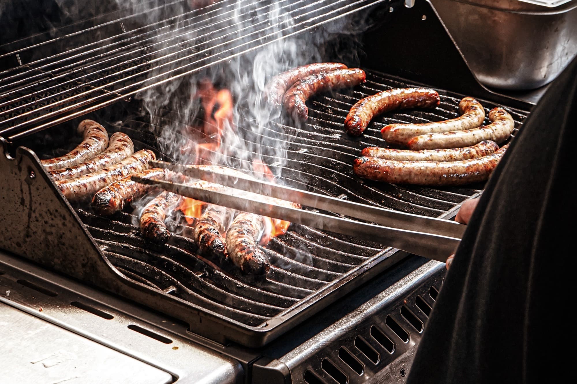 Bratwürste über offener Flamme auf dem Grill
